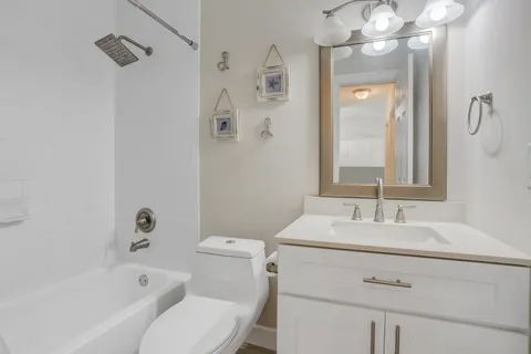 a bedroom with a large bed and a chandelier fan