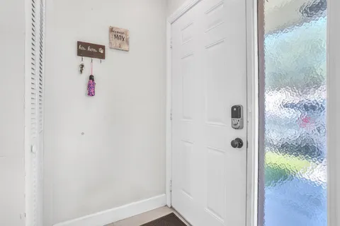 a living room with furniture a flat screen tv and kitchen view