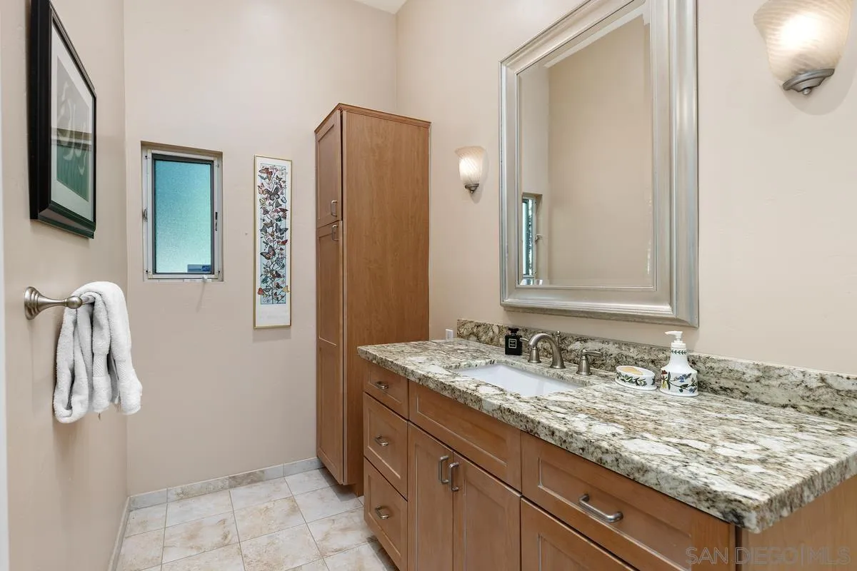 5625 Caminito Isla La Jolla, CA 92037 - Photo 13 of 29 a bathroom with a granite countertop sink and a mirror