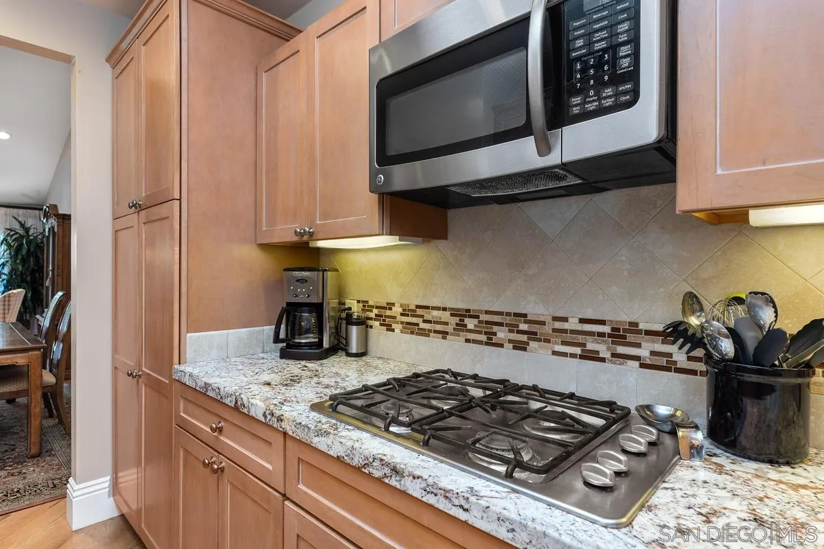 5625 Caminito Isla La Jolla, CA 92037 - Photo 5 of 29 a kitchen with wooden cabinets and a stove top oven