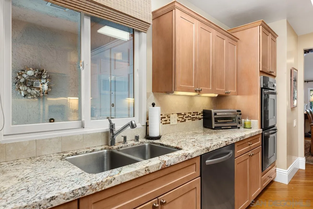 5625 Caminito Isla La Jolla, CA 92037 - Photo 6 of 29 a kitchen with granite countertop a sink a counter top space cabinets and stainless steel appliances