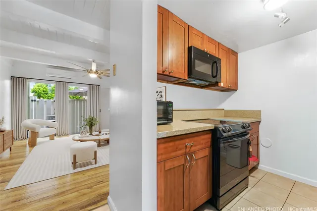 a living room with stainless steel appliances furniture a fireplace and a flat screen tv
