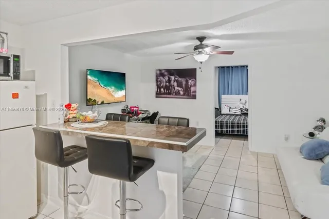 a kitchen with stainless steel appliances kitchen island granite countertop a sink and a refrigerator