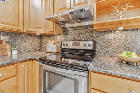 a kitchen with stainless steel appliances granite countertop a stove a sink and a microwave