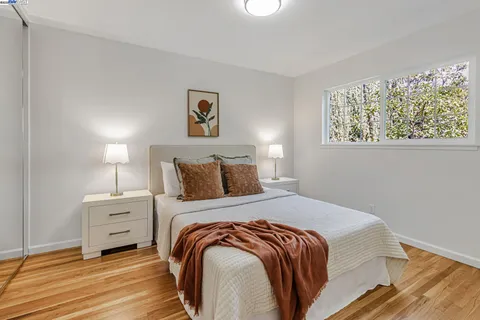 a bedroom with a bed and a painting on the wall