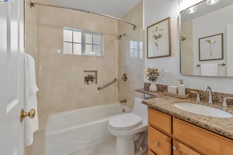 a bathroom with a granite countertop sink a toilet and shower