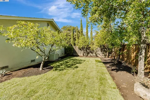 a view of a house with backyard and sitting area