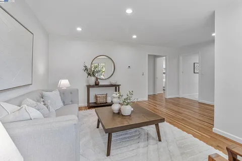 a living room with furniture a clock and a table