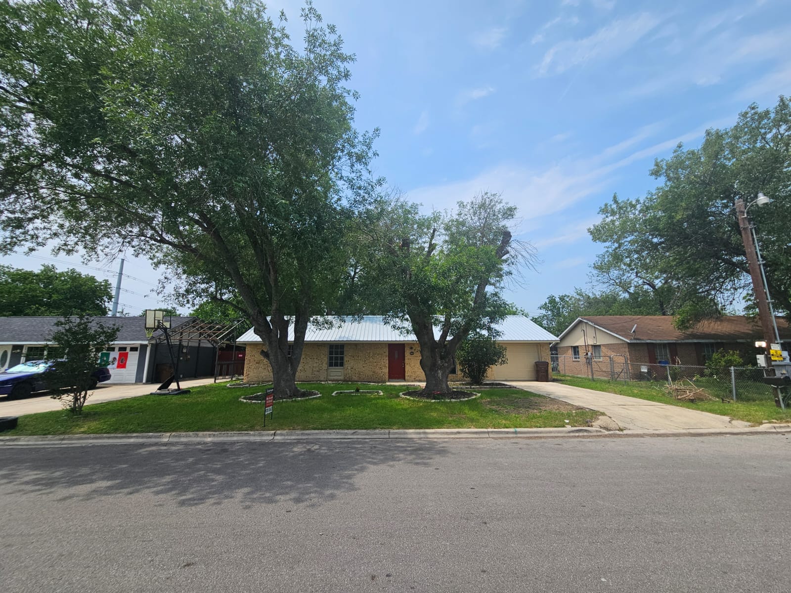 1401 Trinity Street Lockhart, TX 78644 - Photo 2 of 31 One-story residence featuring a metal roof and light-colored brick exterior