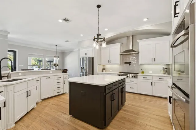 a kitchen with granite countertop a sink stove cabinets and wooden floor