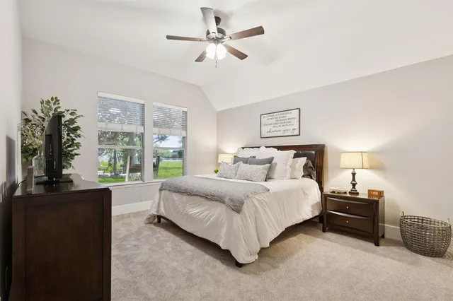 a spacious bedroom with a bed a large window with table and chairs