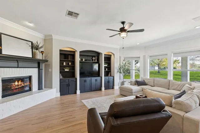 a living room with furniture a fireplace and a floor to ceiling window
