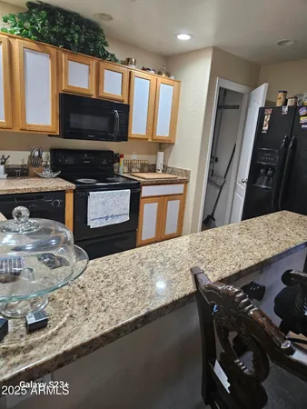 a living room with stainless steel appliances furniture a fireplace and a flat screen tv