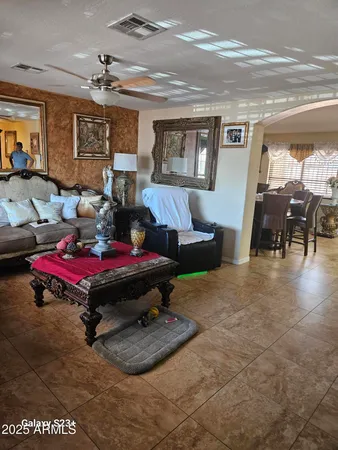 a living room with furniture a dining table and paintings on the wall