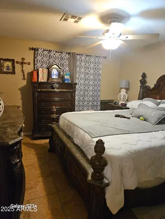a spacious bedroom with a bed and dresser with mirror