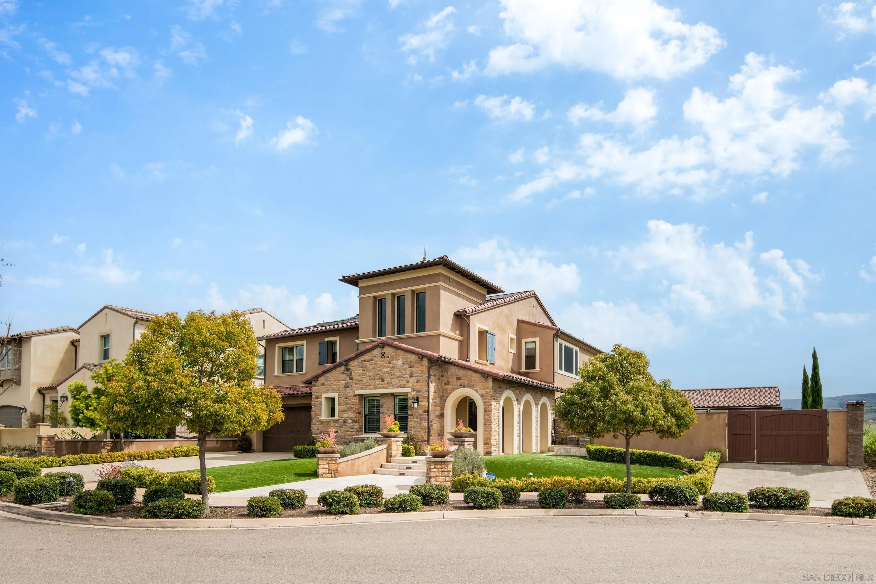a front view of a house with a garden and mountain view