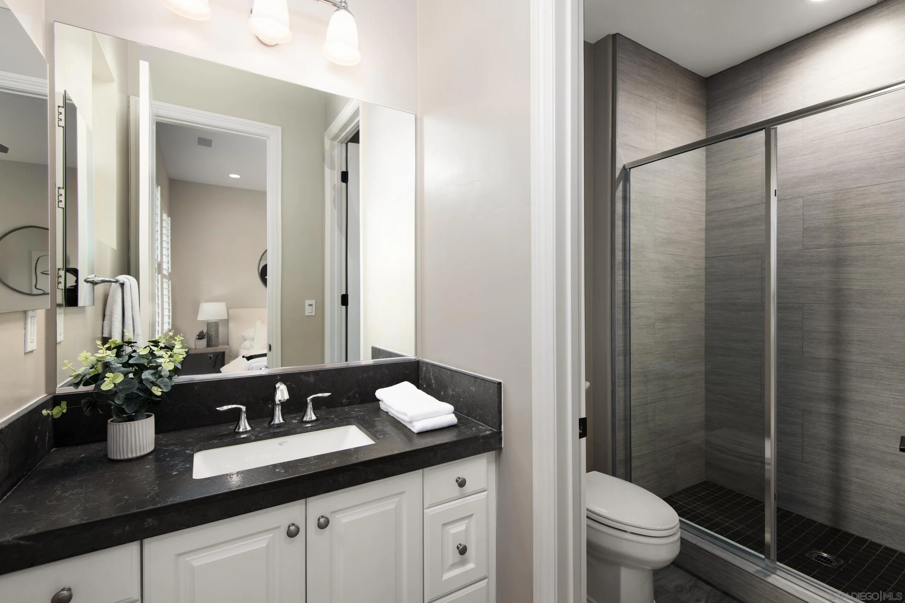 16339 Nicole Ridge Road San Diego, CA 92127 - Photo 34 of 56 a bathroom with a granite countertop sink a toilet a mirror and shower