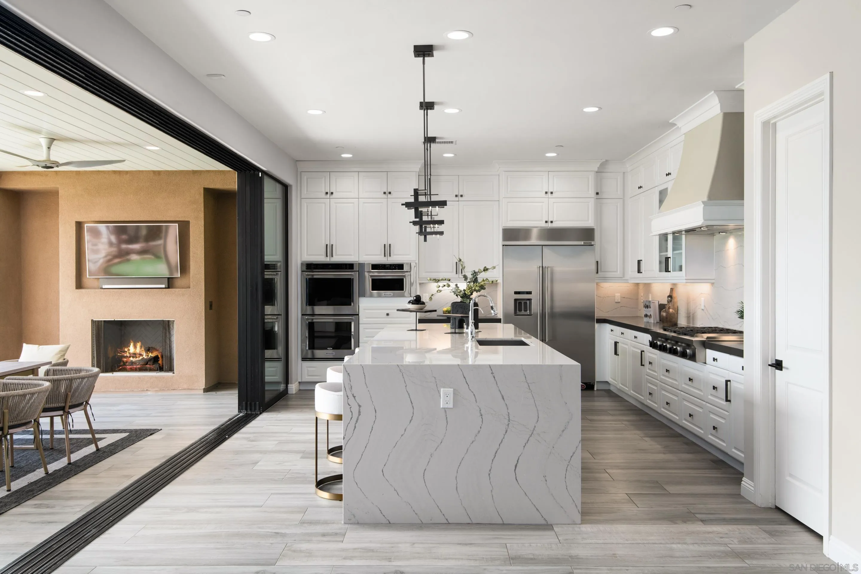 16339 Nicole Ridge Road San Diego, CA 92127 - Photo 5 of 56 a large kitchen with stainless steel appliances kitchen island granite countertop a stove a refrigerator a oven and a dining table with wooden floor