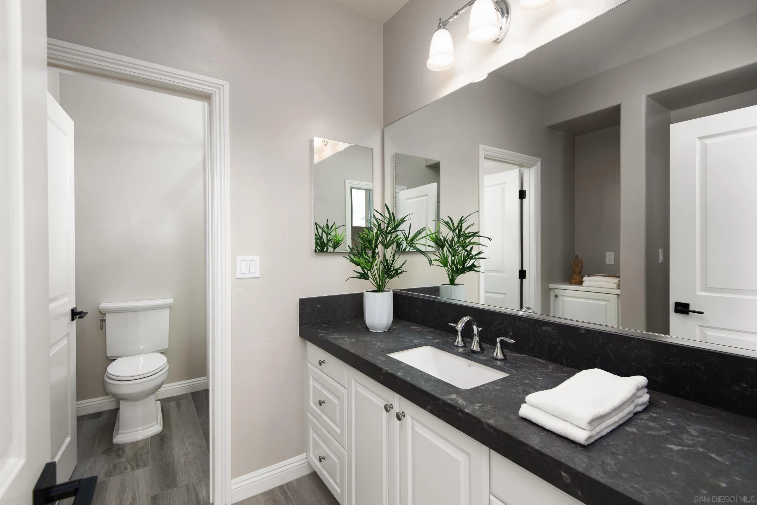 16339 Nicole Ridge Road San Diego, CA 92127 - Photo 51 of 56 a bathroom with a granite countertop sink a toilet and a mirror