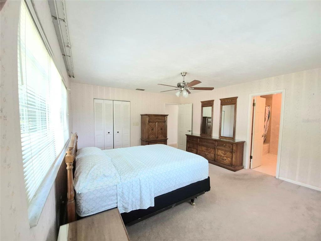 25632 Southwest 19 Avenue Newberry, FL 32669 - Photo 10 of 20 a bedroom with a large bed a chandelier and dresser