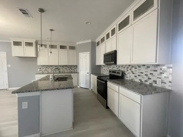 a kitchen with stainless steel appliances granite countertop a sink and a stove
