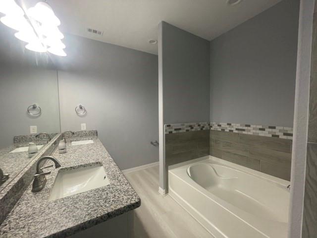 938 Genesis Road Rice, TX 75155 - Photo 9 of 13 a bathroom with a granite countertop sink a mirror and bathtub