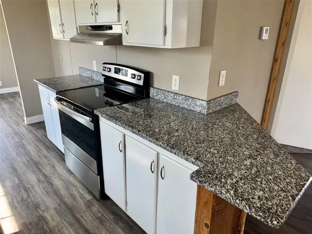 a kitchen with stainless steel appliances granite countertop a sink stove and cabinets
