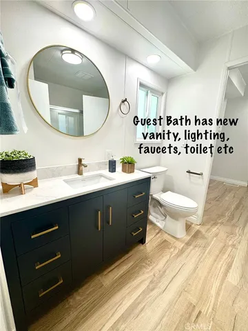 a bathroom with a sink mirror vanity and toilet