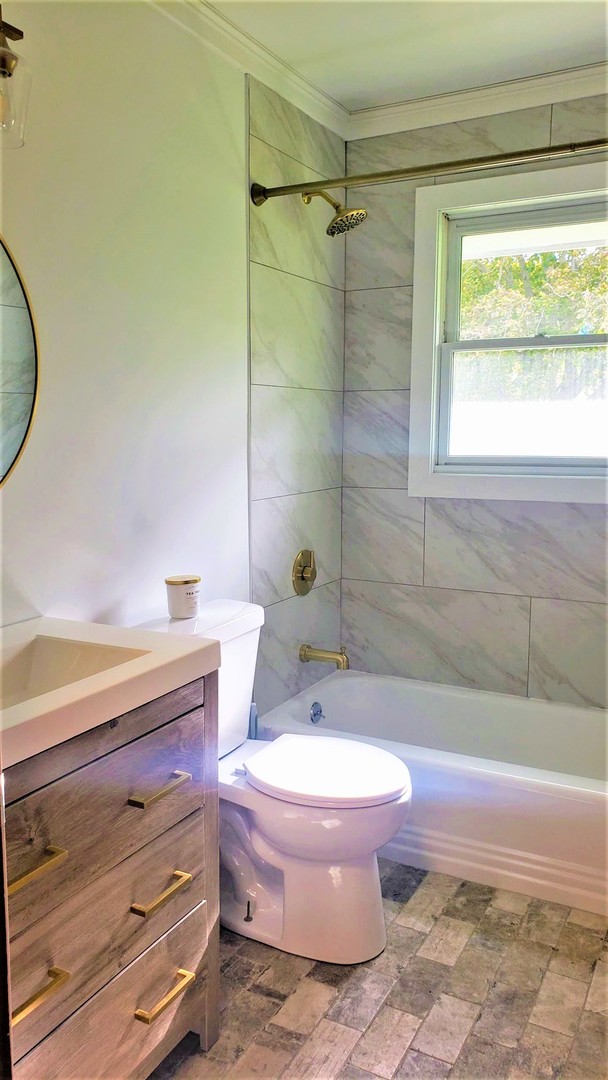 14375 Derby Line Road Genoa, IL 60135 - Photo 8 of 19 a bathroom with a granite countertop toilet a sink and bathtub