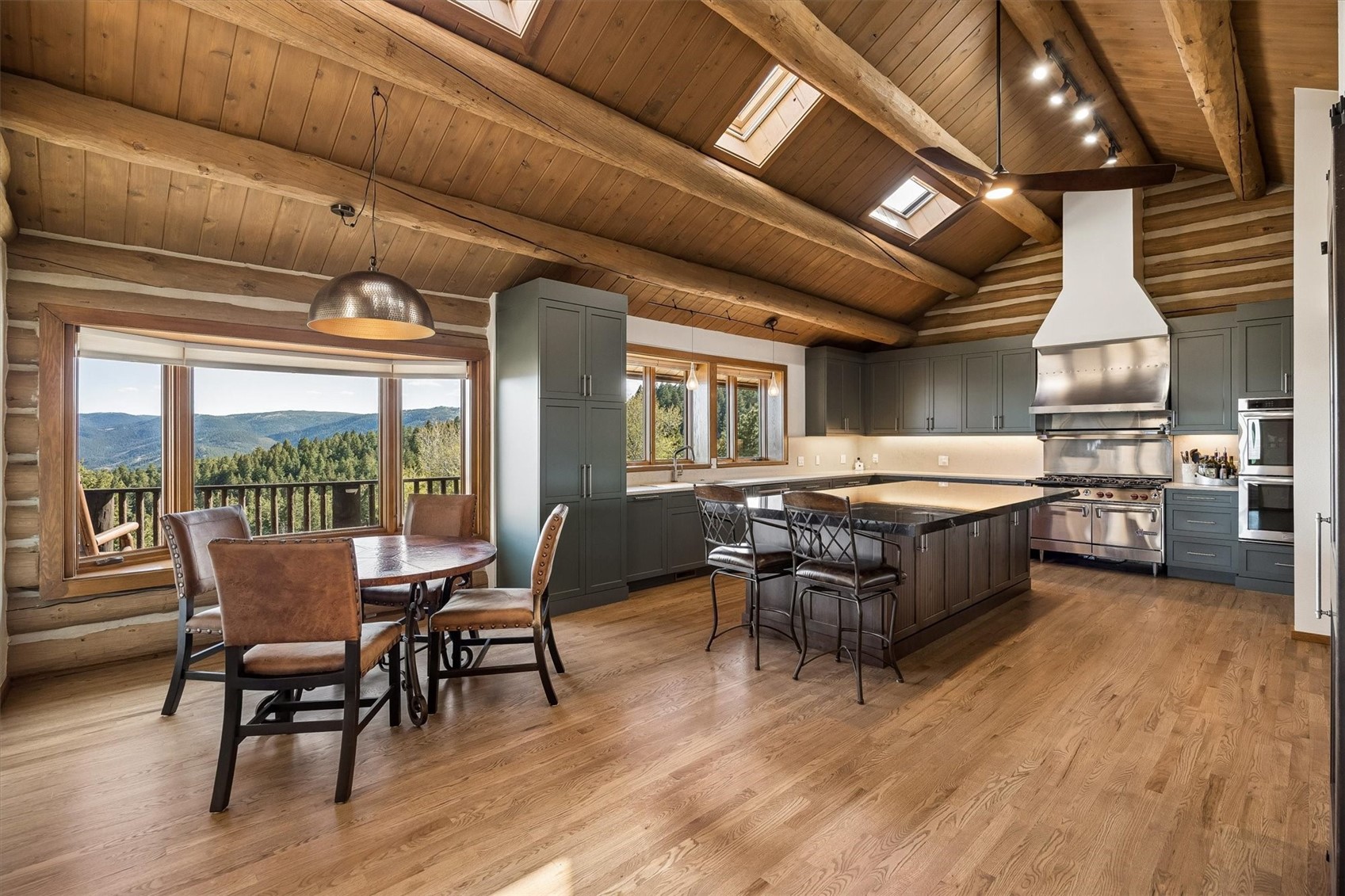 51 West Ranch Trail Morrison, CO 80465 - Photo 5 of 50 a dining hall with couches a dining table and chairs with wooden floor
