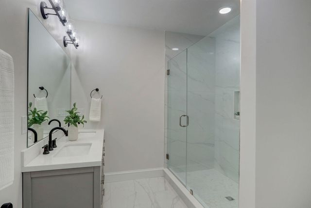 a bathroom with a sink a mirror and a shower