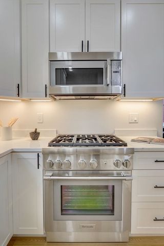a stove top oven sitting inside of a kitchen