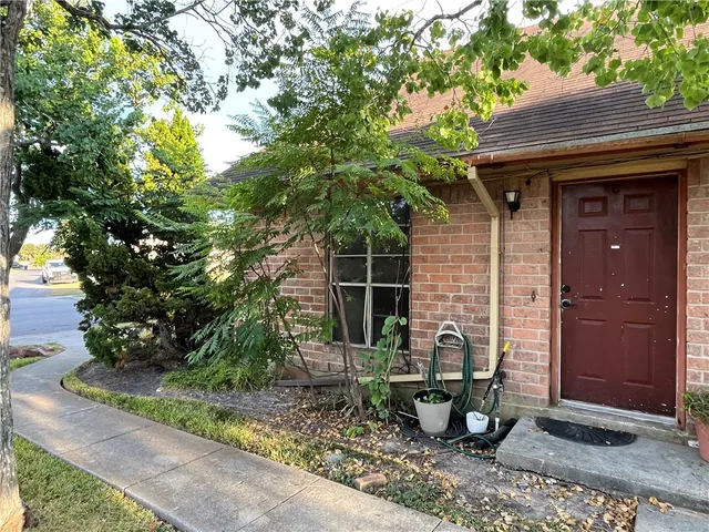 a view of a chair and table in backyard of the house