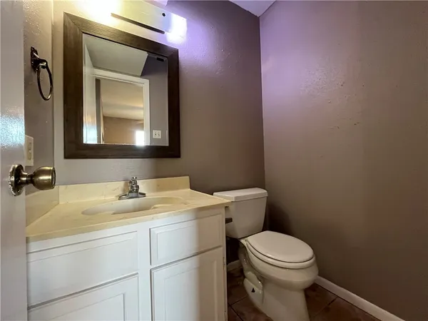 a bathroom with a toilet sink vanity and mirror