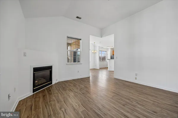 an empty room with wooden floor and a window