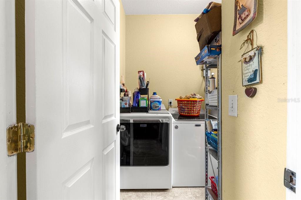 12345 Northeast 14th Avenue Anthony, FL 32617 - Photo 58 of 91 a kitchen with a refrigerator and white cabinets