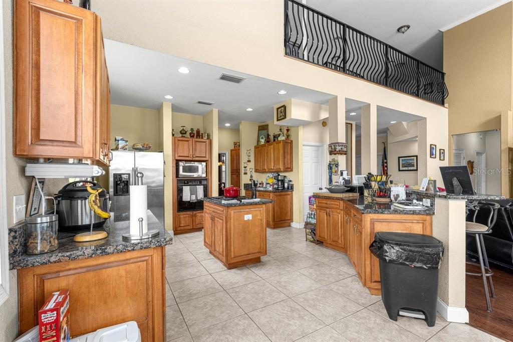 12345 Northeast 14th Avenue Anthony, FL 32617 - Photo 59 of 91 a kitchen with stainless steel appliances kitchen island granite countertop a table chairs and a refrigerator