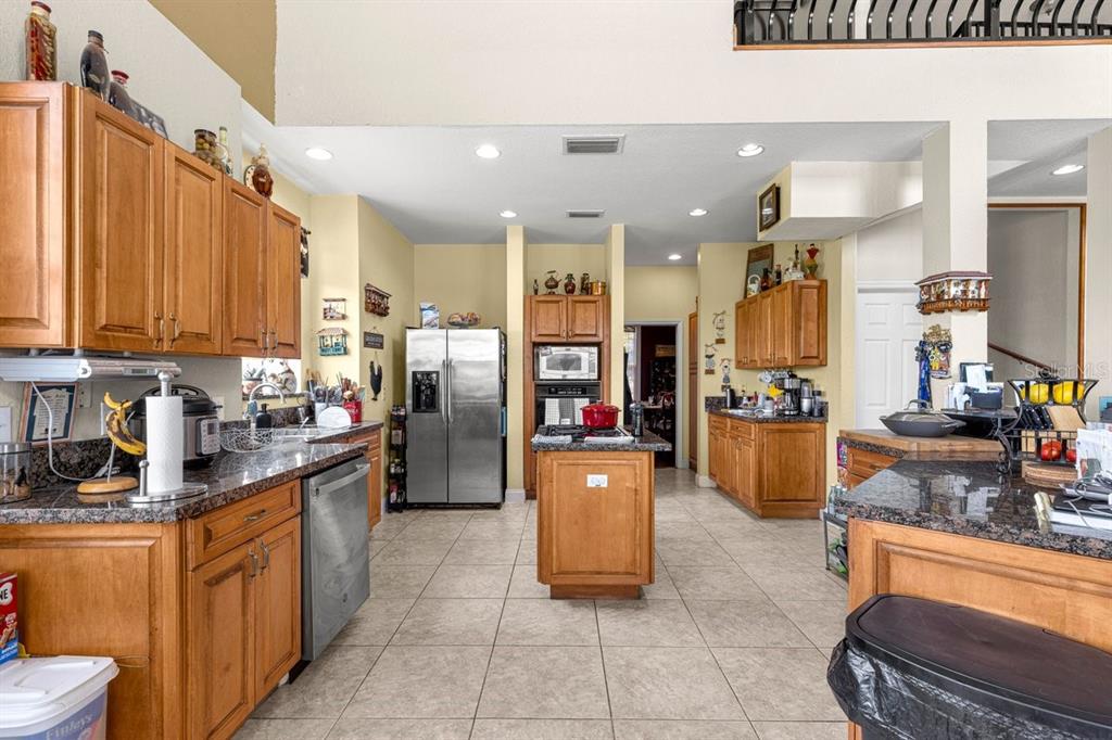 12345 Northeast 14th Avenue Anthony, FL 32617 - Photo 60 of 91 a kitchen with stainless steel appliances kitchen island granite countertop a refrigerator a stove top oven and a sink