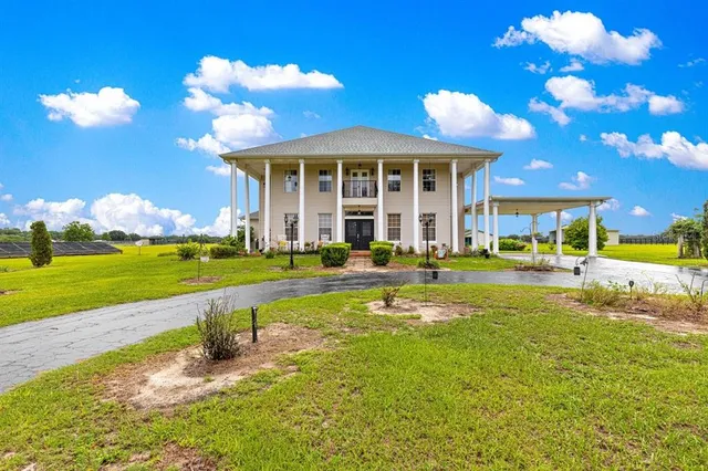 a view of a house with swimming pool and a yard