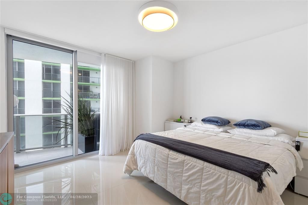 488 Northeast 18th Street, Unit 2010 Miami, FL 33132 - Photo 11 of 15 a bedroom with a bed and a window