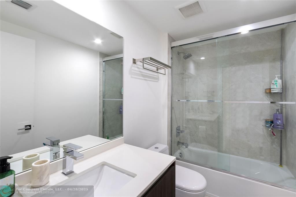 488 Northeast 18th Street, Unit 2010 Miami, FL 33132 - Photo 12 of 15 a bathroom with a granite countertop sink toilet and shower