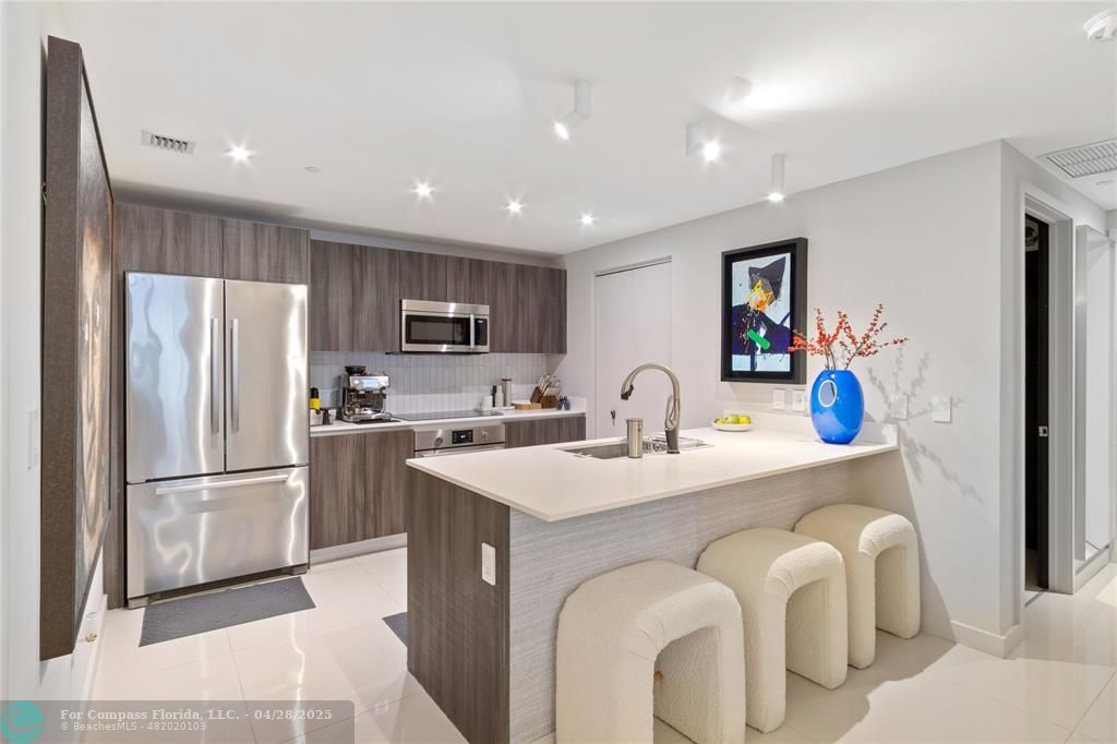 488 Northeast 18th Street, Unit 2010 Miami, FL 33132 - Photo 3 of 15 a kitchen with stainless steel appliances granite countertop a sink refrigerator and cabinets