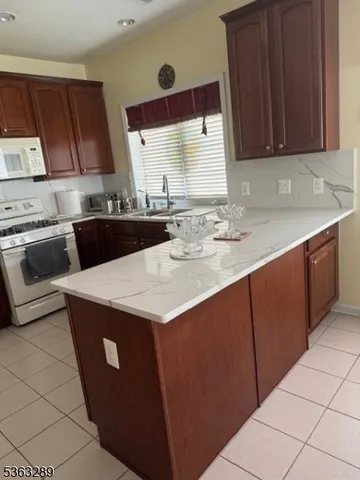 a living room with hard wood flooring and white appliances