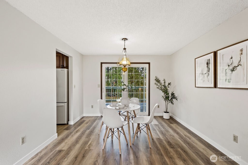 4813 208th Street East Spanaway, WA 98387 - Photo 14 of 39 a view of a room with wooden floor windows and chandelier