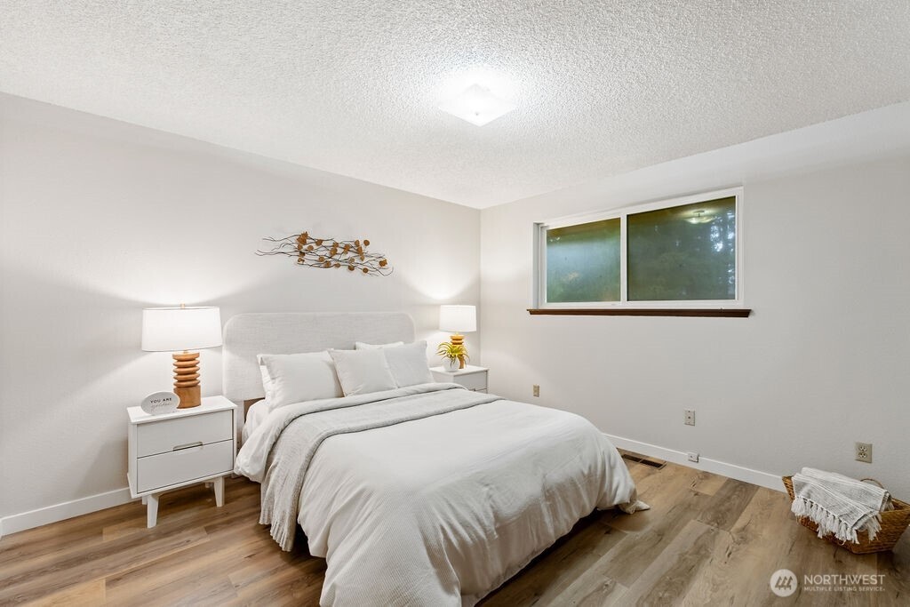 4813 208th Street East Spanaway, WA 98387 - Photo 18 of 39 a bedroom with a bed and wooden floor