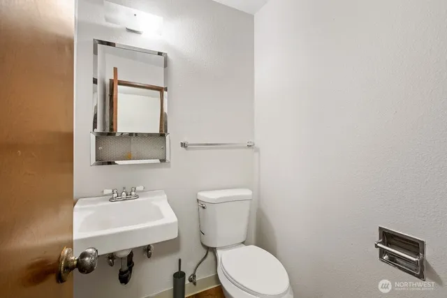 a bathroom with a toilet a sink and mirror