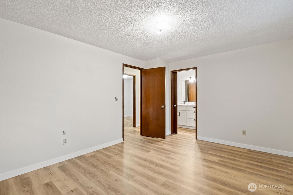 4813 208th Street East Spanaway, WA 98387 - Photo 25 of 39 an empty room with wooden floor and windows