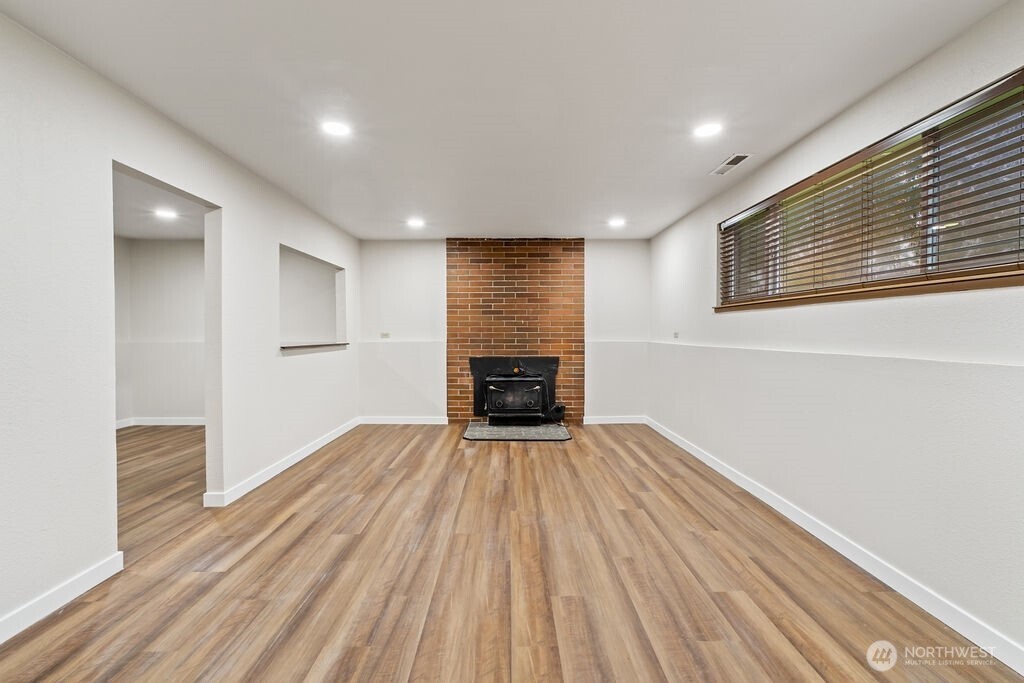4813 208th Street East Spanaway, WA 98387 - Photo 26 of 39 a view of a room with wooden floor fireplace and a window