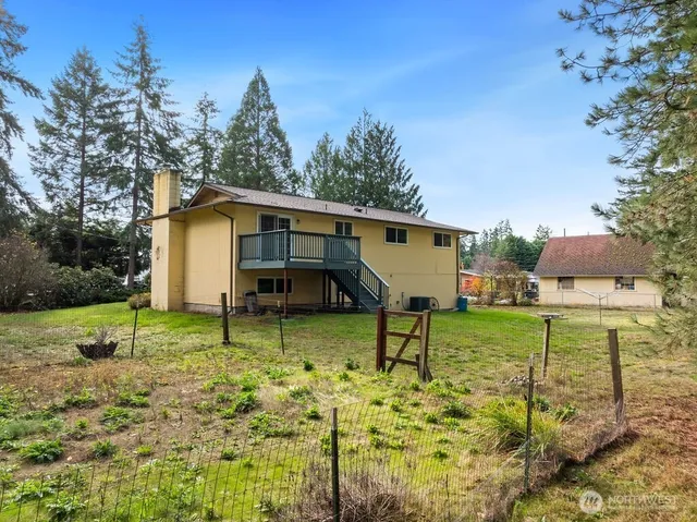a view of backyard with table and chairs and wooden fence