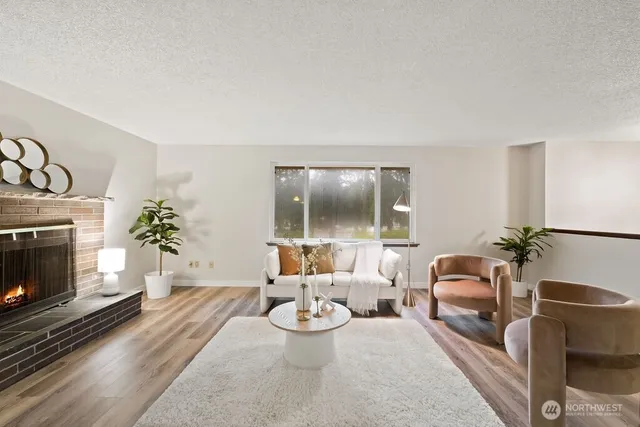 a living room with furniture a fireplace and a potted plant